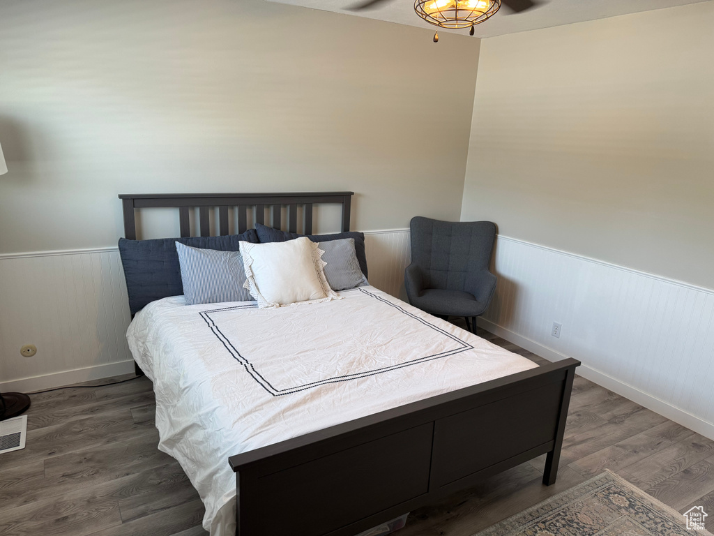 Bedroom featuring wainscoting and wood finished floors