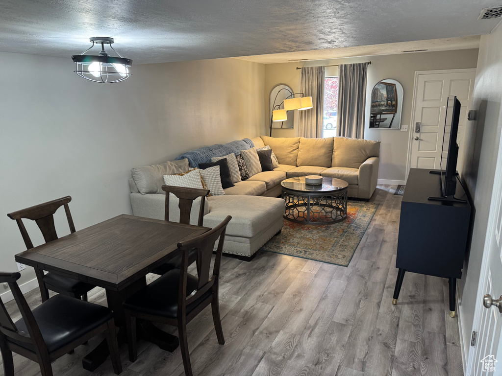 Dining space with light wood-style floors and a textured ceiling
