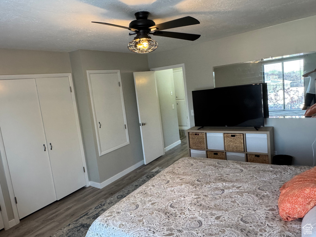 Bedroom featuring wood finished floors, a textured ceiling, and a ceiling fan