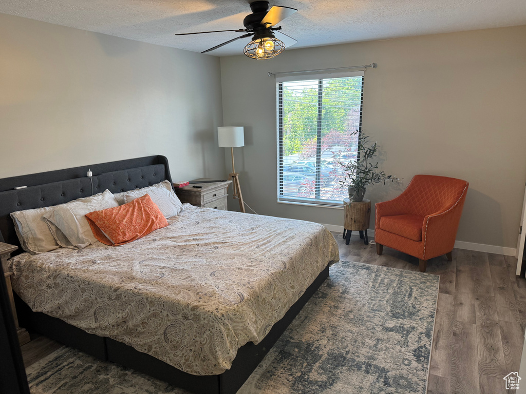 Bedroom featuring wood finished floors, a textured ceiling, and ceiling fan