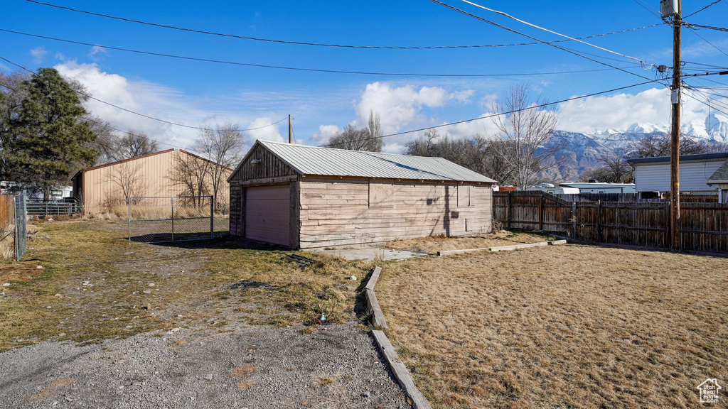 View of outbuilding featuring a fenced backyard and a mountain view