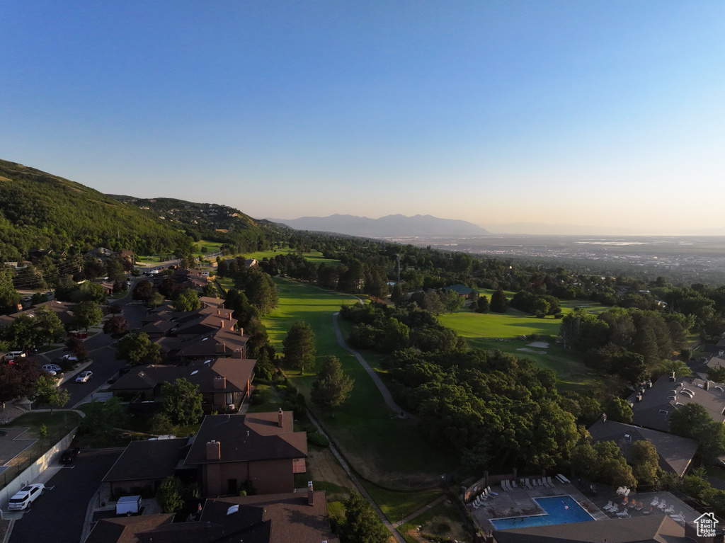 Aerial view of property and surrounding area with a mountain backdrop and a golf club