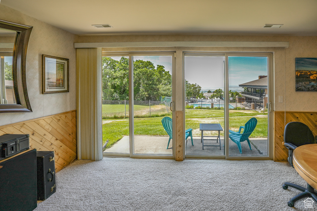 Office featuring carpet floors, plenty of natural light, wooden walls, and wainscoting