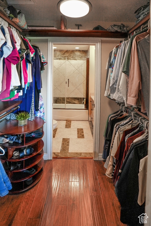Walk in closet with wood-type flooring