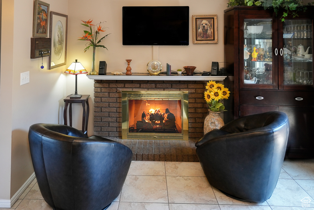 Living room featuring a brick fireplace and baseboards