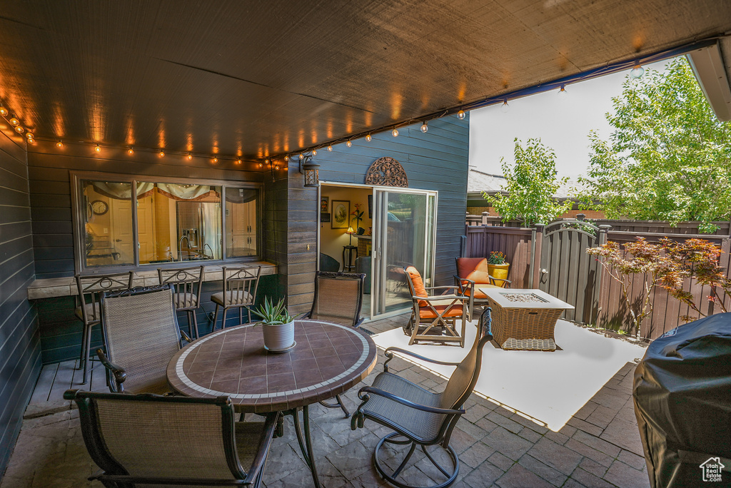 View of patio with outdoor dining space, grilling area, and a gate