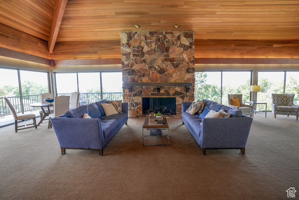 Carpeted living room featuring plenty of natural light, wood ceiling, and wood walls