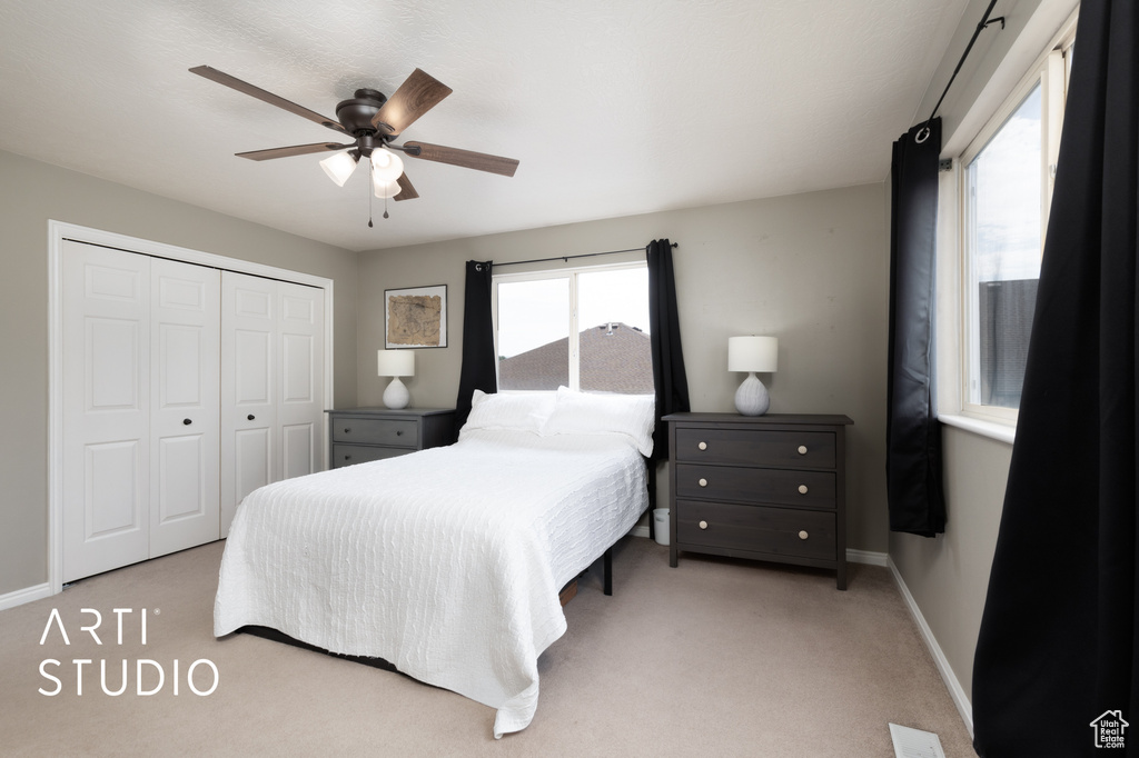 Carpeted bedroom featuring a closet and a ceiling fan