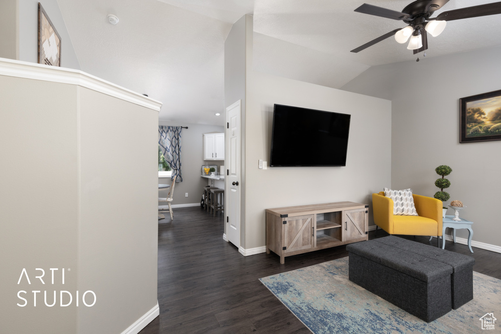 Living room with a ceiling fan, dark wood-style floors, and lofted ceiling