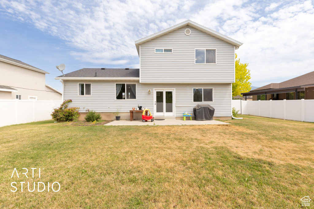 Rear view of house with a patio and a fenced backyard