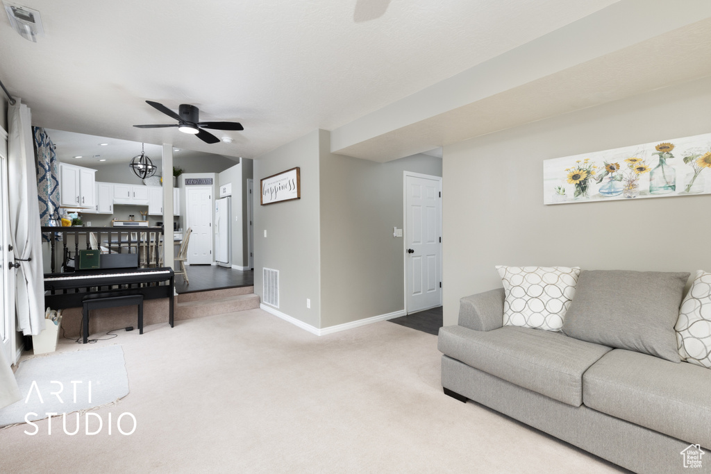 Living room featuring ceiling fan and light colored carpet