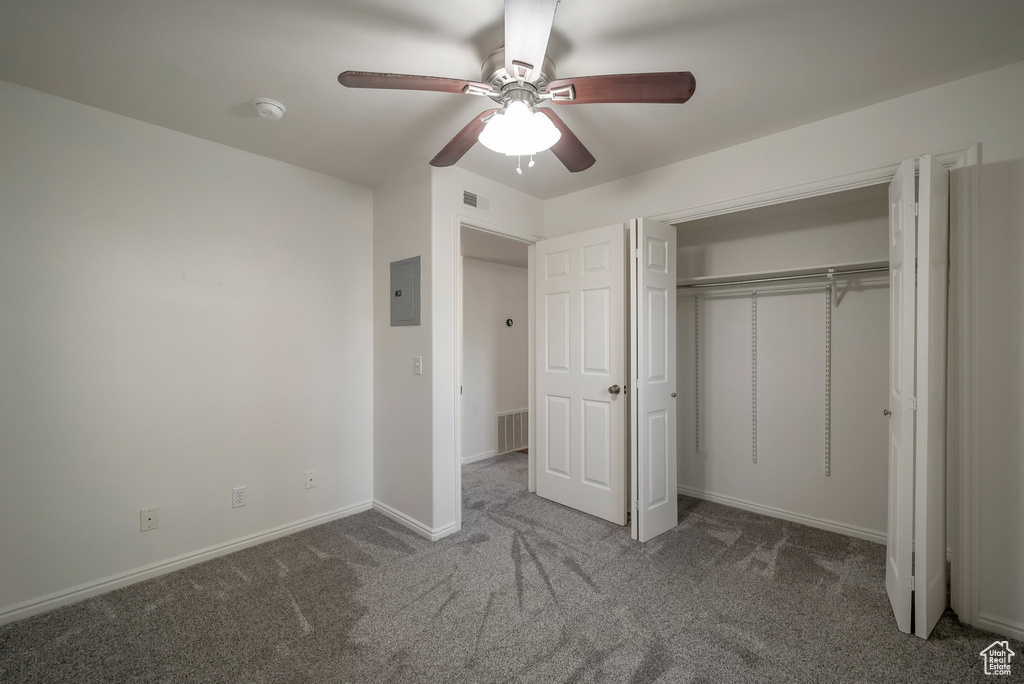 Unfurnished bedroom with carpet flooring, a closet, a ceiling fan, and electric panel