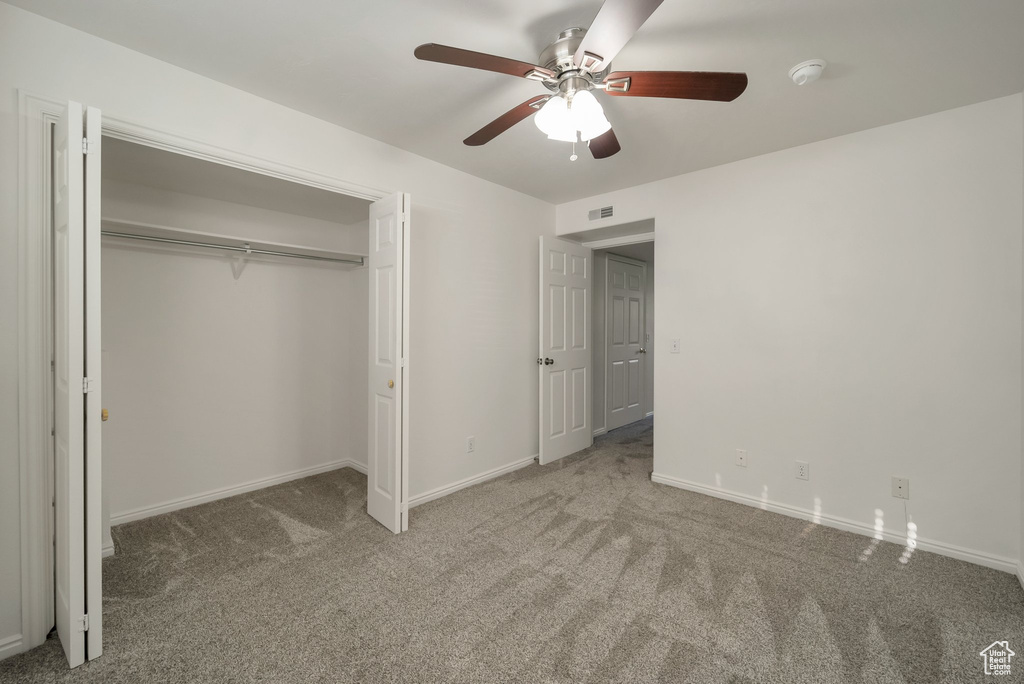Unfurnished bedroom featuring carpet, a closet, and a ceiling fan