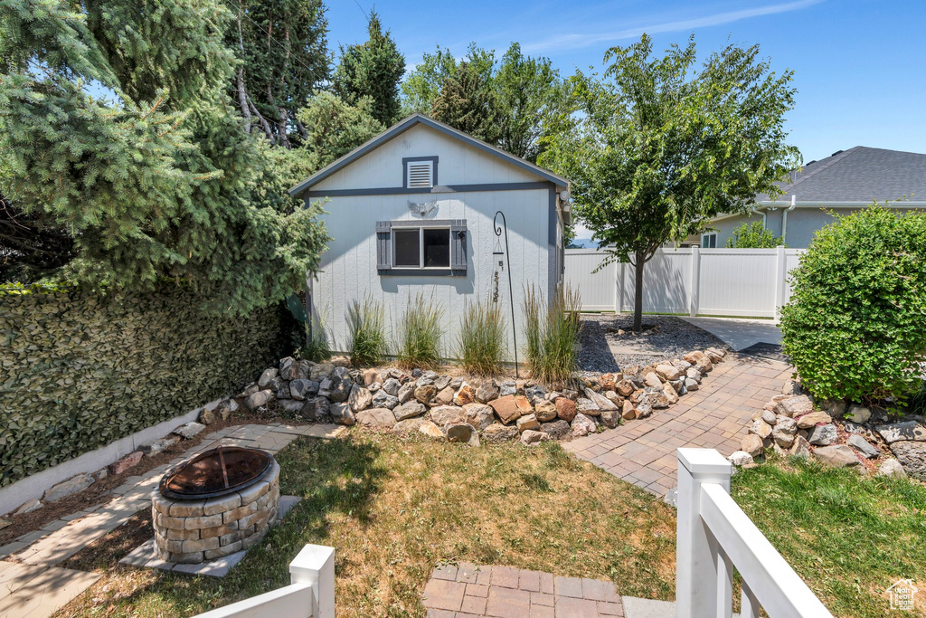 View of front of house featuring an outdoor fire pit and an outdoor structure