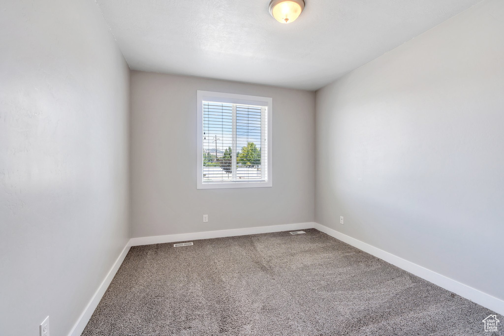 Spare room featuring carpet and baseboards