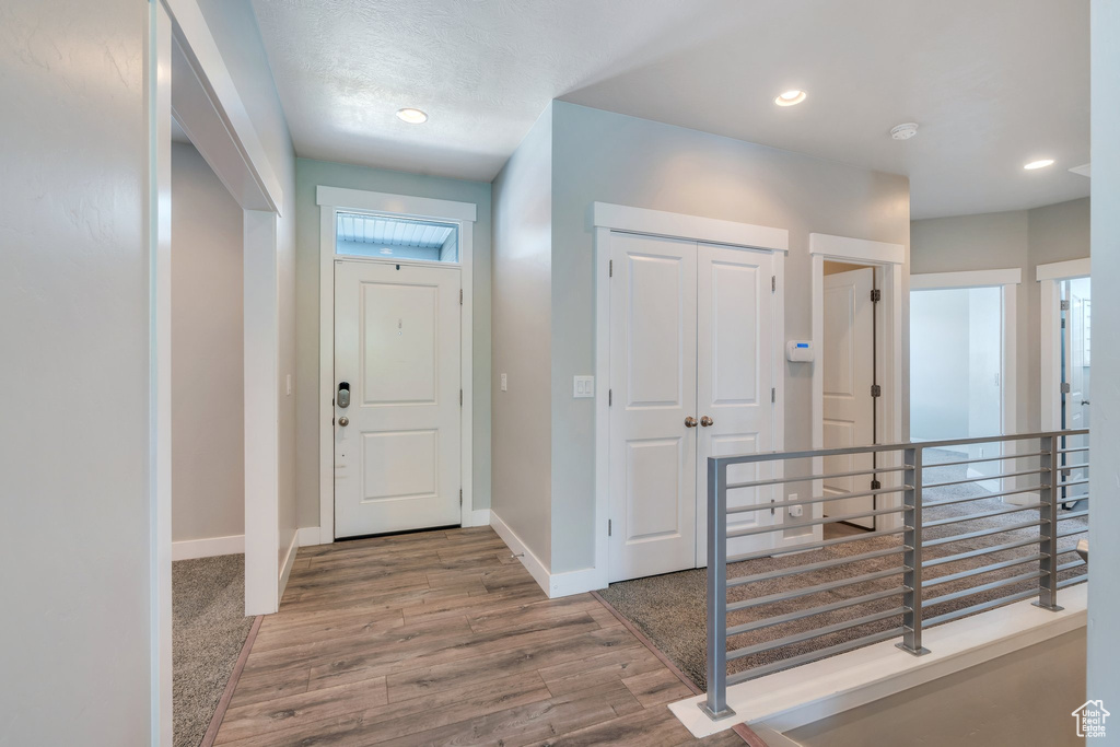 Entrance foyer with wood finished floors and recessed lighting