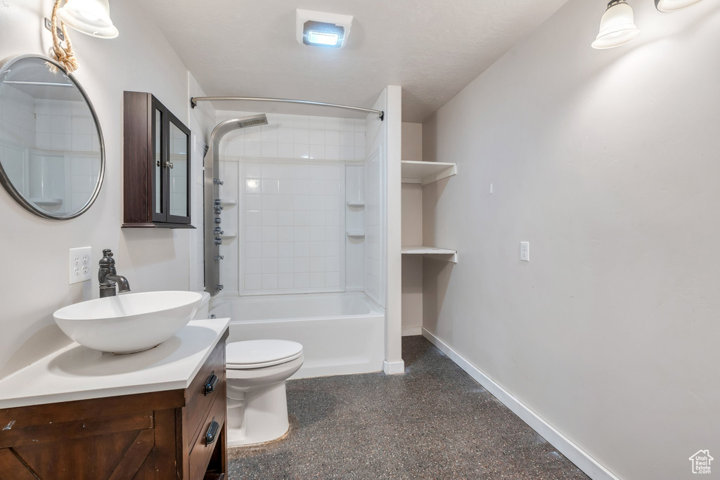 Bathroom featuring vanity, shower / tub combination, and speckle patterned floor