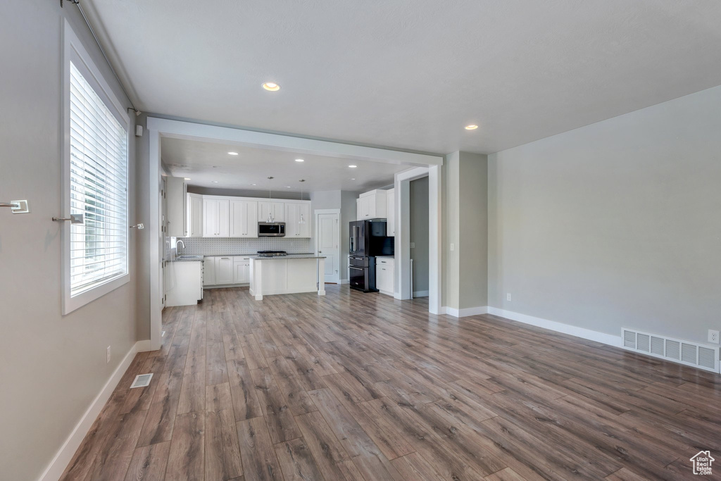Unfurnished living room with recessed lighting, wood finished floors, and healthy amount of natural light