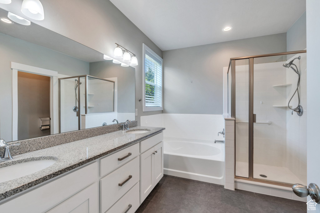 Bathroom with tile patterned floors, a shower stall, a bath, double vanity, and recessed lighting