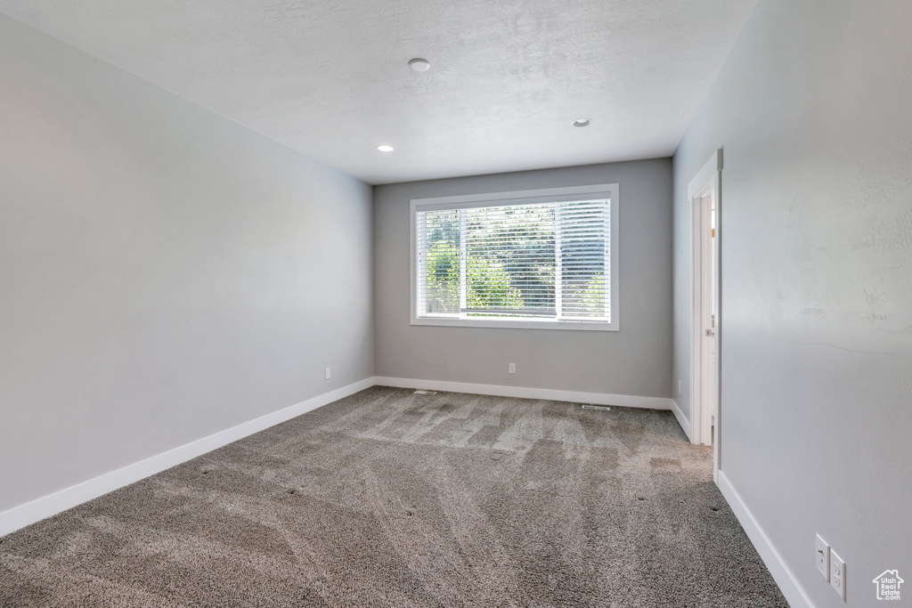 Carpeted spare room featuring baseboards and recessed lighting
