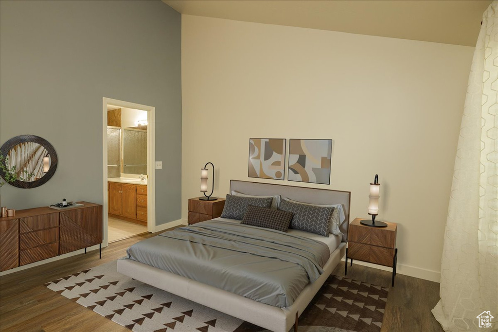 Bedroom with wood finished floors, a high ceiling, and ensuite bathroom