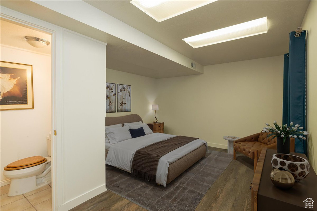 Bedroom featuring wood finished floors and connected bathroom