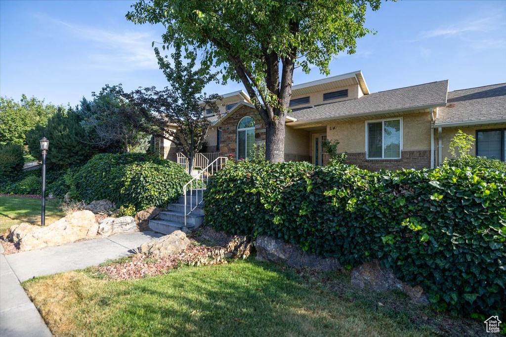 View of front of home with stucco siding and a front yard