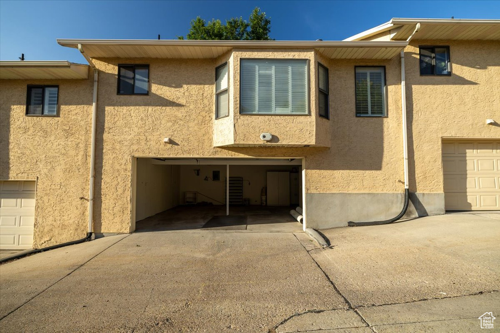 View of front of home featuring driveway, stucco siding, and a garage