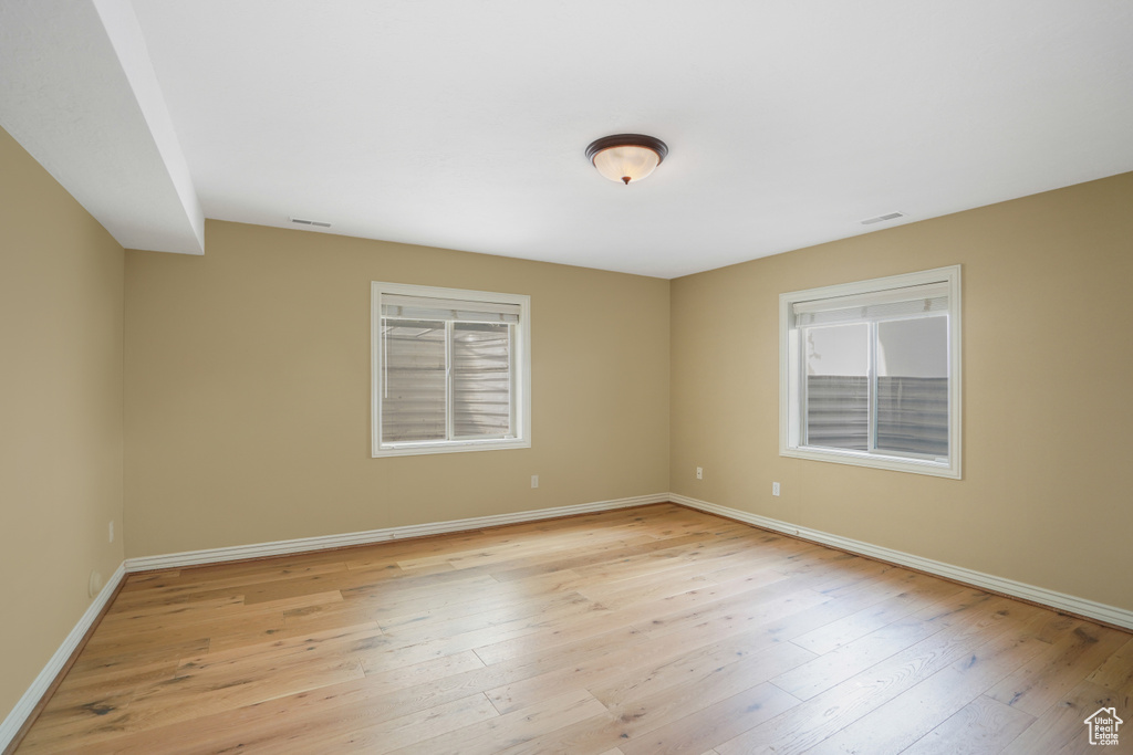 Empty room featuring baseboards and light wood finished floors