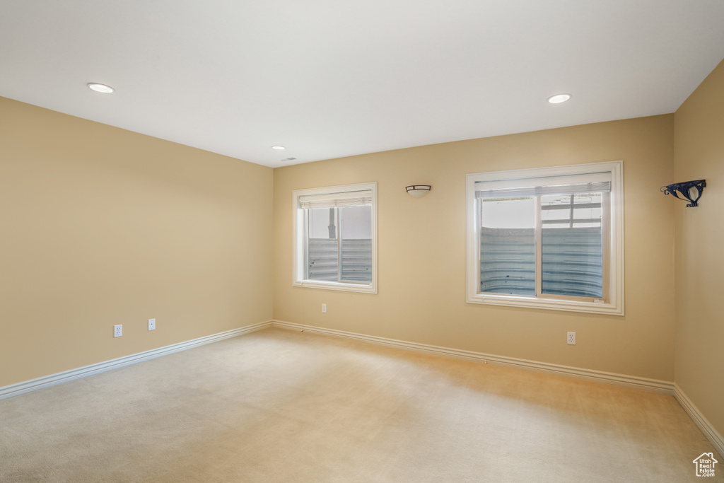 Unfurnished room featuring healthy amount of natural light, light colored carpet, and recessed lighting
