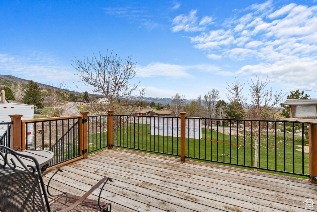 Deck with a yard and a mountain view