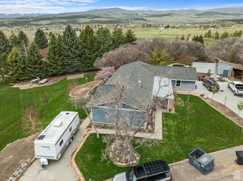 Aerial view of property and surrounding area featuring a mountain backdrop