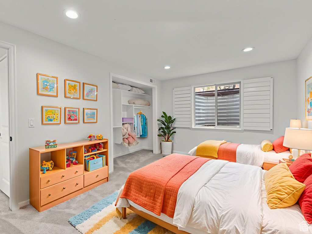 Bedroom featuring light colored carpet, a closet, and recessed lighting