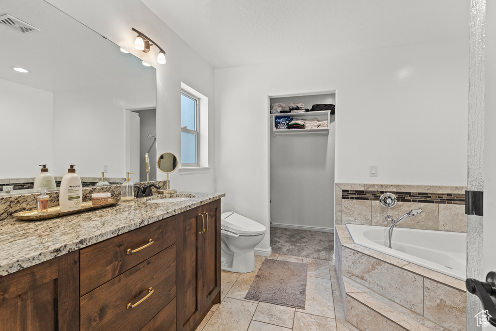 Full bath with vanity and a garden tub