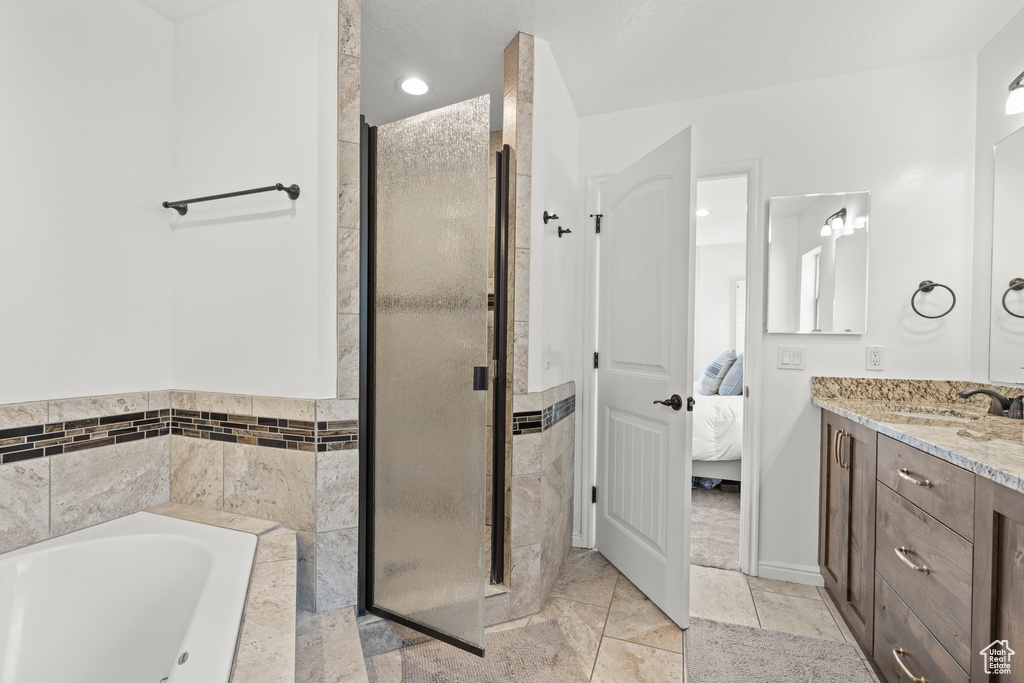 Ensuite bathroom featuring vanity, a stall shower, a bath, tile patterned flooring, and recessed lighting