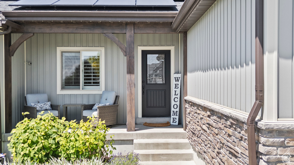 Property entrance featuring roof mounted solar panels and stone siding