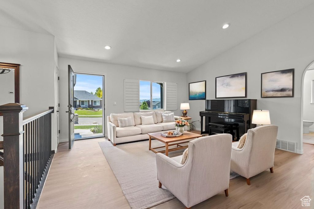 Living area featuring light wood finished floors, recessed lighting, and vaulted ceiling
