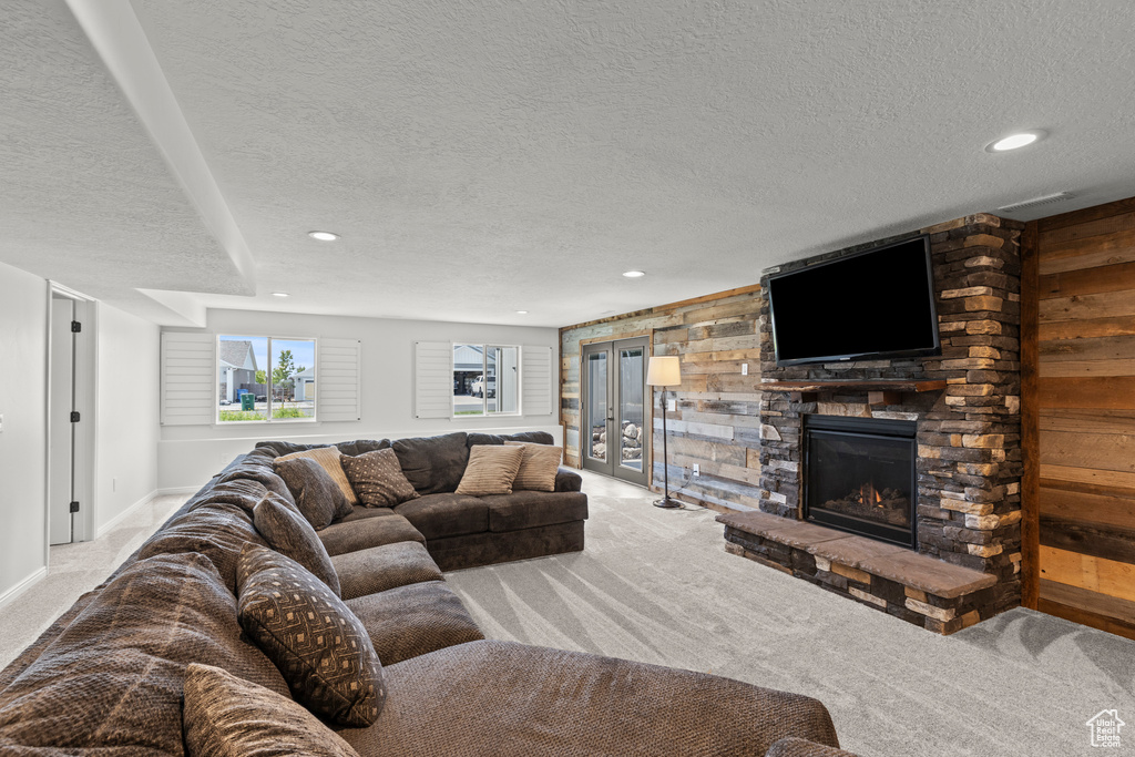 Carpeted living room featuring a textured ceiling, a fireplace, and recessed lighting