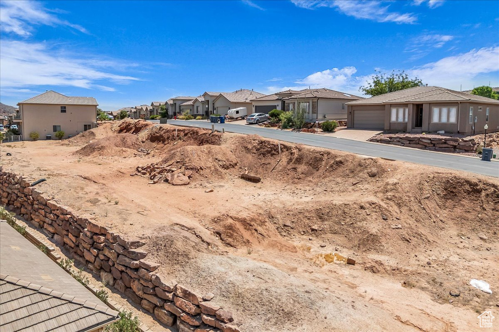 View of yard featuring a residential view, an attached garage, and concrete driveway