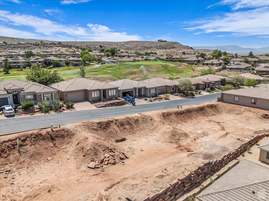 Aerial perspective of suburban area with mountains and a golf club