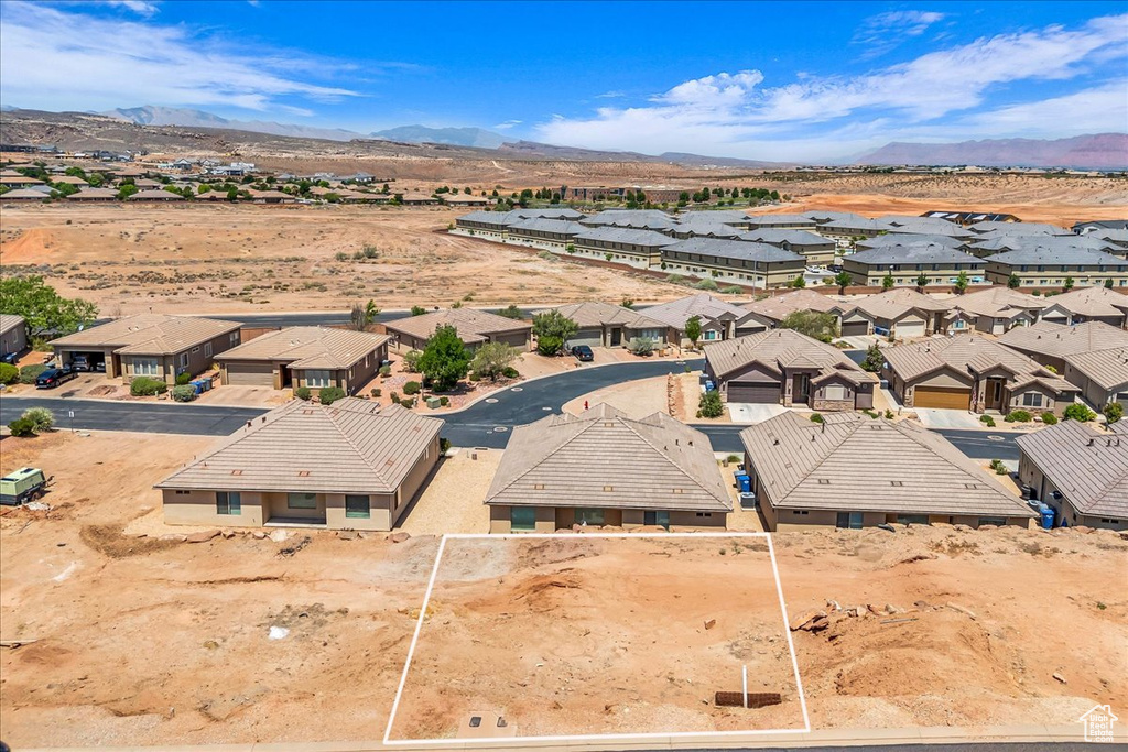 Aerial view of residential area featuring a mountainous background and a desert landscape