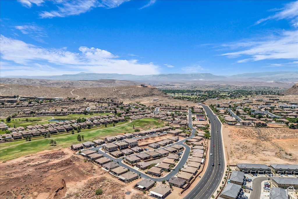 Aerial perspective of suburban area with a mountainous background and a golf course
