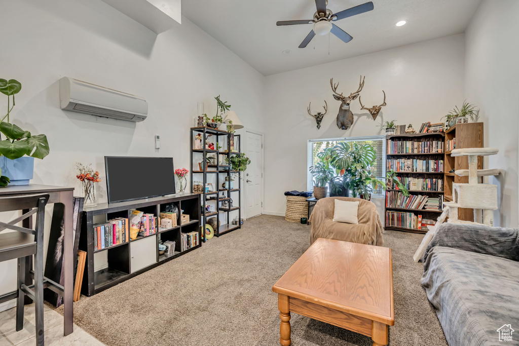 Carpeted living area featuring a wall unit AC, ceiling fan, and recessed lighting