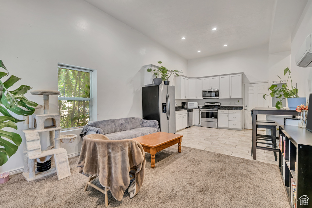 Living room featuring a towering ceiling, recessed lighting, light tile patterned flooring, and a wall unit AC