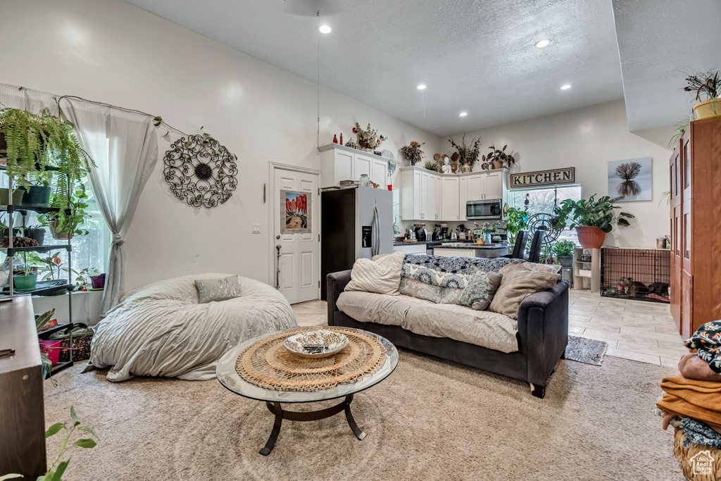 Living room featuring recessed lighting, a textured ceiling, and a towering ceiling
