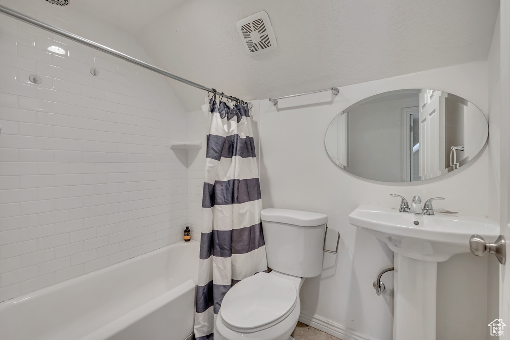 Full bathroom with shower / bath combo with shower curtain and vaulted ceiling