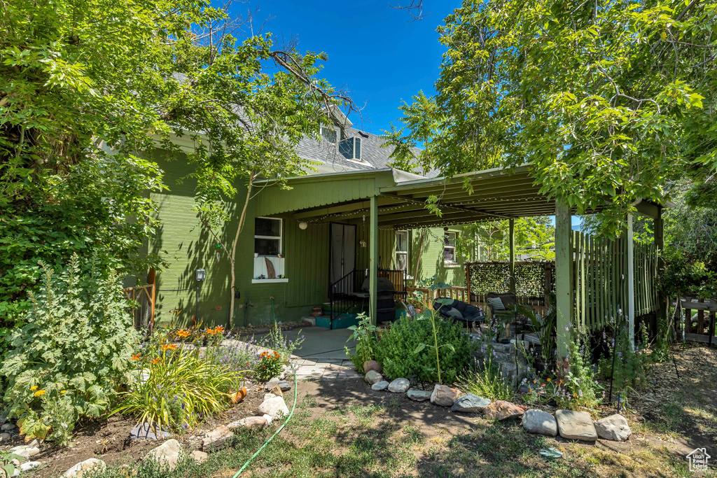 Rear view of property featuring roof with shingles
