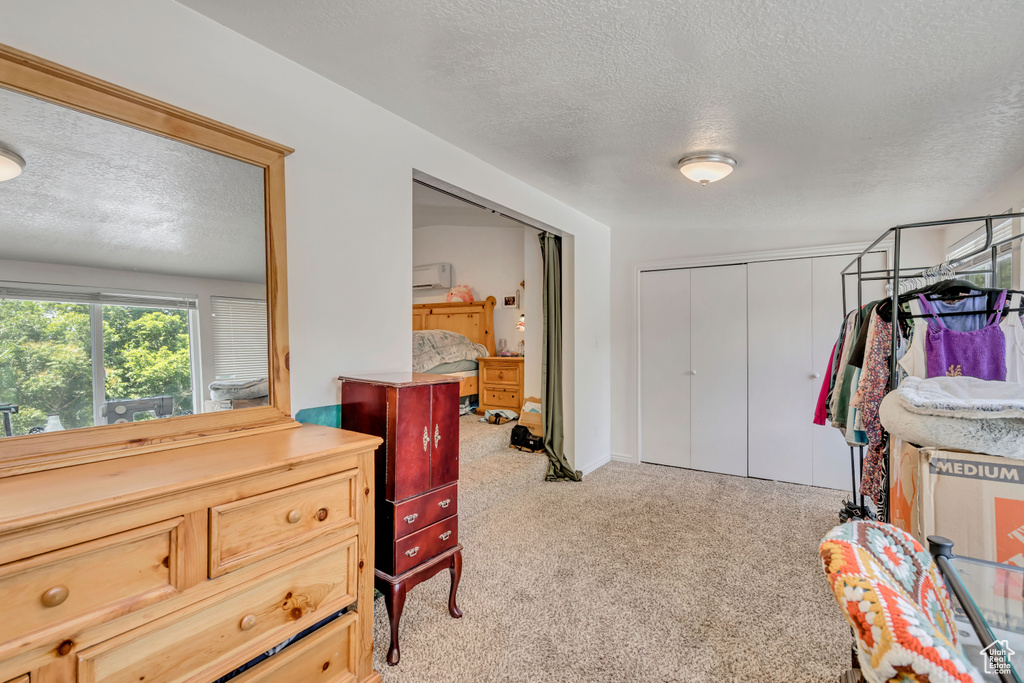 Bedroom featuring a textured ceiling, carpet, and a closet