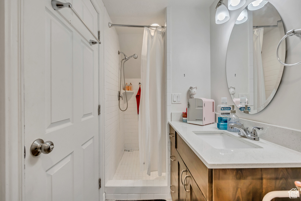 Full bathroom with vanity and a shower stall