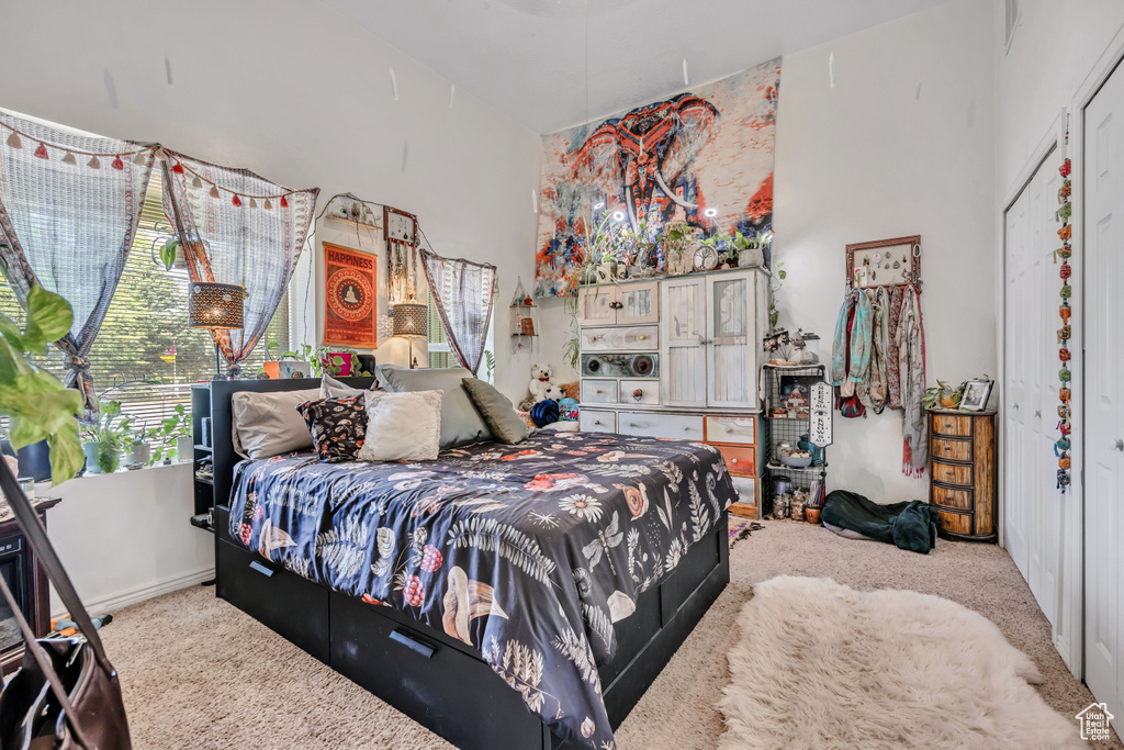 Bedroom with carpet, multiple windows, and a closet